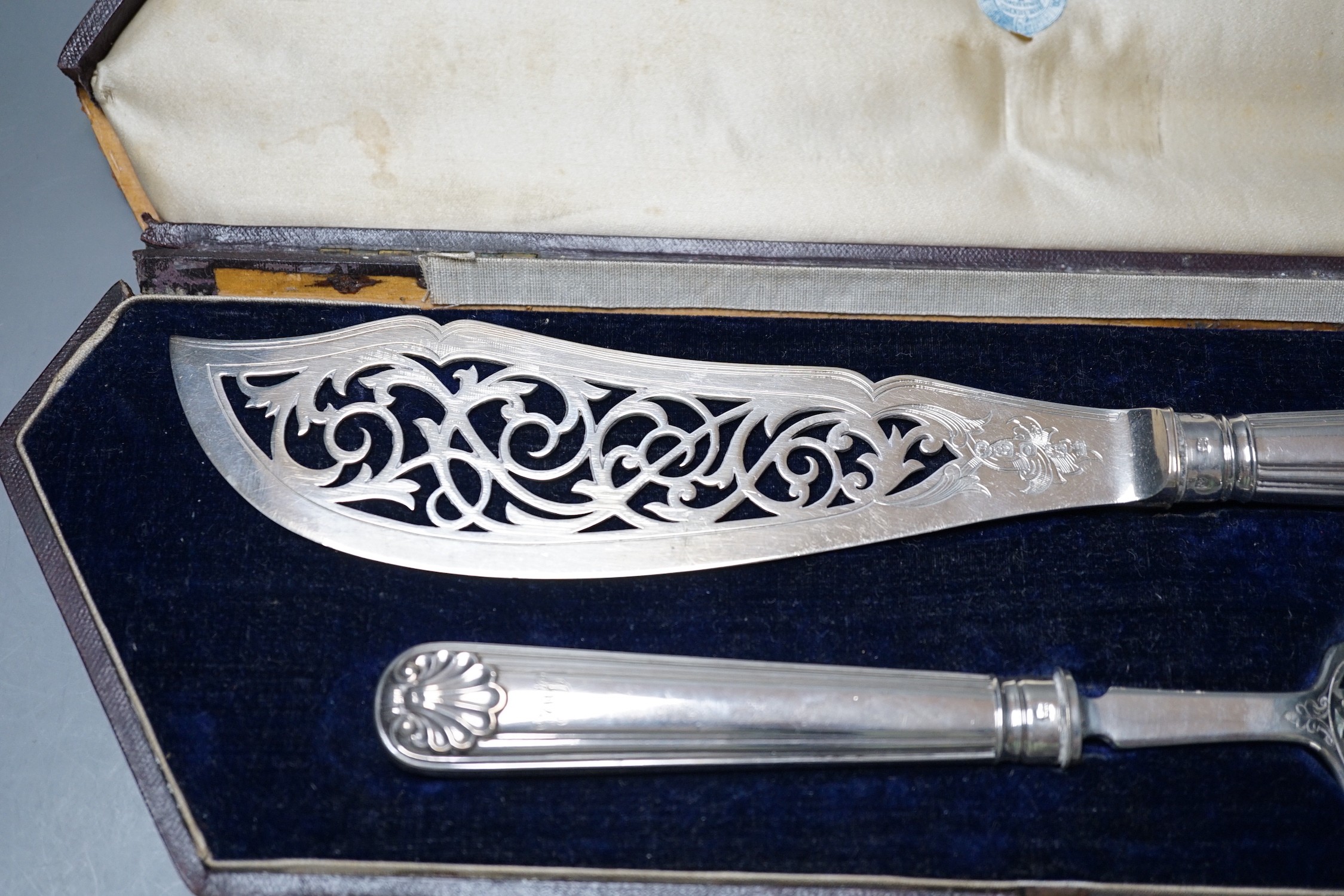 A cased pair of Victorian silver fish servers, Martin, Hall & Co, Sheffield, 1857, knife 31.2, loaded handles.